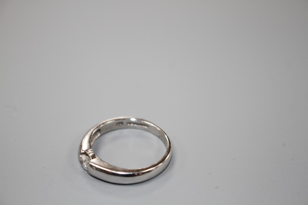 A modern 18ct white gold channel set solitaire diamond ring, size L, gross weight 3.6 grams.